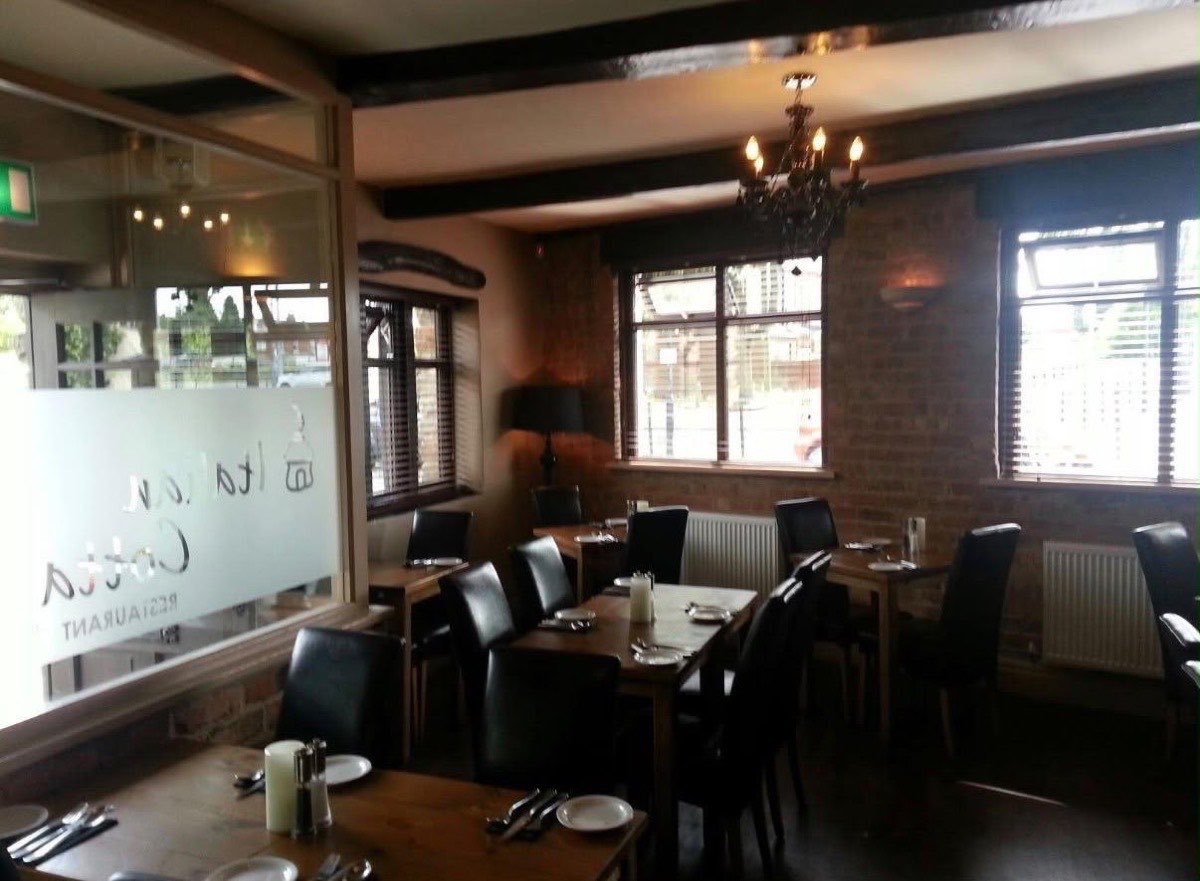 The dining room, with exposed brick walls, wooden tables and leather chairs by the front window